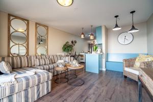 a living room with couches and a kitchen at Beachfront Luxury Living- A106 Seaspray, Blouberg in Bloubergstrand