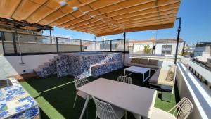 a patio with a table and chairs on a balcony at RentalSevilla Real de la Carretería in Seville