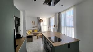a kitchen and living room with a sink and a counter at RentalSevilla Real de la Carretería in Seville