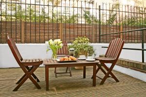 a table and two chairs with a plate of food on a patio at Collingham Serviced Apartments in London +36 photos
