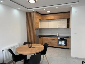 una cucina con un tavolo di legno e sedie nere di Apartman Biser 5 a Ruma