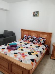 a bed with a wooden frame with a cow quilt on it at Jeni's studio in Constanţa +3 photos
