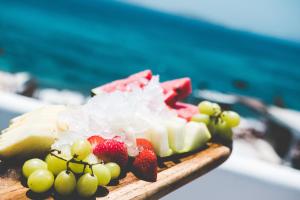 a plate of food with fruit on a table at Hippie Chic Hotel in Agios Ioannis Mykonos