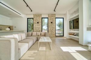 a living room with a couch and a table at Luxury Oasis Villa in Peyia