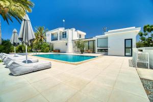 a villa with a swimming pool and a house at Luxury Oasis Villa in Peyia