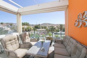 a patio with chairs and a table with a view at Fabuloso ático en el centro in Arguineguín