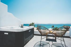 a hot tub on a balcony with a view of the ocean at Hippie Chic Hotel in Agios Ioannis Mykonos
