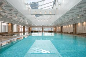 a large swimming pool with blue water in a building at The Westin Beijing Financial Street in Beijing