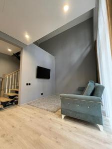 a living room with a couch and a tv on a wall at Ormanhouse in Shchūchīnsk