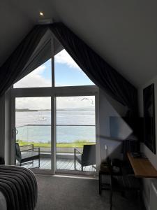 a bedroom with a large window with a view of the ocean at Oyster Inn Connel in Oban