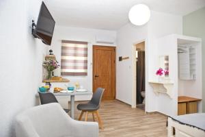 a small living room with a table and chairs at Skalopati Studios & Villa in Panormos Skopelos