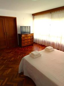 a bedroom with a bed with two towels on it at Pensión La Plaza in Betanzos +28 photos