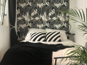 a black and white bedroom with a bed with zebra pillows at La Joueuse, Et pop Et Chic ! in Poitiers