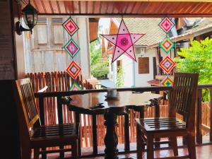 a table and chairs on a screened in porch at Apple Guesthouse in Luang Prabang