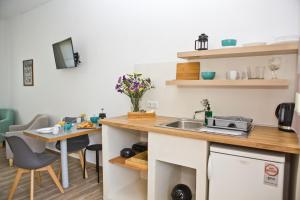 a kitchen with a sink and a table at Skalopati Studios & Villa in Panormos Skopelos