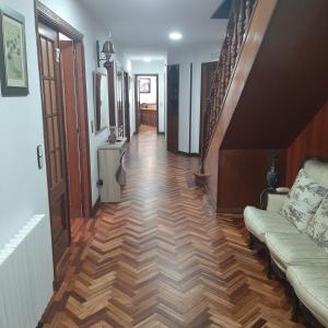 a hallway with a couch and stairs in a house at Pensión La Plaza in Betanzos