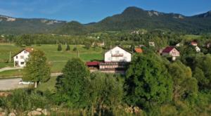 eine Gruppe von Häusern auf einem Feld mit Bäumen in der Unterkunft Restora Točak Mokro Rooms in Mokro