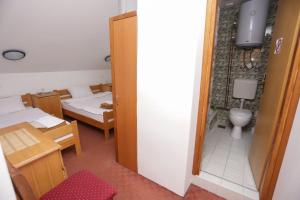 ein Zimmer mit einem Zimmer mit zwei Betten und einer Toilette in der Unterkunft Restora Točak Mokro Rooms in Mokro