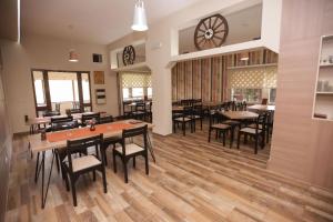 ein Restaurant mit Tischen und Stühlen und einer Uhr an der Wand in der Unterkunft Restora Točak Mokro Rooms in Mokro + 11 Fotos