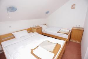 2 Betten in einem kleinen Zimmer mit 2 Tischen in der Unterkunft Restora Točak Mokro Rooms in Mokro