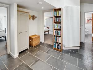 a room with a book shelf and a room with books at St Anthony's Cottage in Porlock