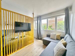 a living room with a couch and a tv at Appartement élégant et cosy - 4Pers in Juvisy-sur-Orge
