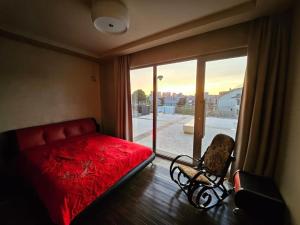 a bedroom with a red bed and a chair and a window at Retro Villa in Batumi +17 photos