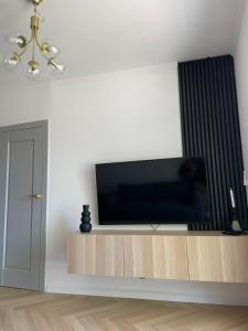 a living room with a flat screen tv on a entertainment center at Apartament Sun in Sztutowo