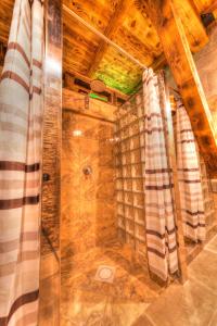 a shower in a room with a wooden ceiling at Etno Village Cardaci in Vitez