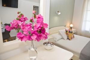 a vase with pink flowers on a table in a living room at Skalopati Studios & Villa in Panormos Skopelos