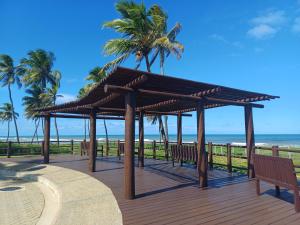 a wooden deck with benches on the beach at Village Baixio in Baixio