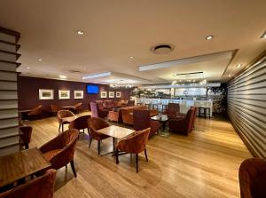 a restaurant with tables and chairs and a bar at Garden Court Nelson Mandela Boulevard in Cape Town