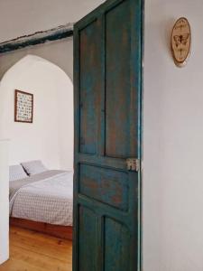 a green door in a bedroom with a bed at Cozy Home with Mountain View Terraces in Chefchaouene