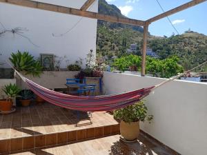 a hammock on a balcony with a view of a mountain at Cozy Home with Mountain View Terraces in Chefchaouene