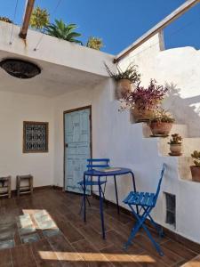 a patio with a table and chairs and a door at Cozy Home with Mountain View Terraces in Chefchaouene