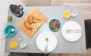 a table with plates of food and glasses of orange juice at Skalopati Studios & Villa in Panormos Skopelos