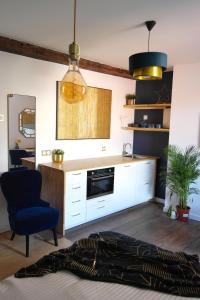 a living room with a fireplace and a blue chair at La Céleste, Et Pop Et Chic ! in Poitiers