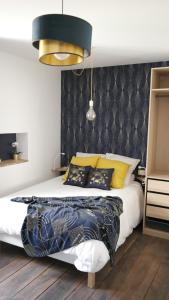 a bedroom with a bed with yellow and black pillows at La Céleste, Et Pop Et Chic ! in Poitiers