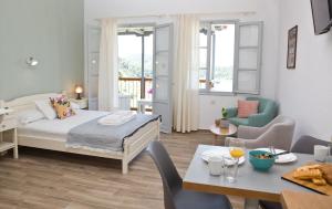 a bedroom with a bed and a table and chairs at Skalopati Studios & Villa in Panormos Skopelos