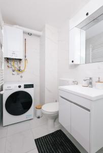 bagno bianco con servizi igienici e forno a microonde. di Apartman Biser 5 a Ruma