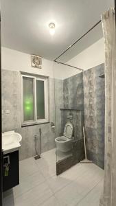 a bathroom with a toilet and a sink and a shower at Serene Home Islamabad in Islamabad