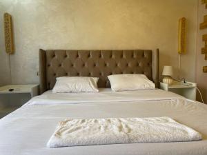 a bedroom with a large bed with white sheets and pillows at زهرة المدائن in Jerash