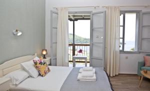 a bedroom with a bed with a view of the ocean at Skalopati Studios & Villa in Panormos Skopelos