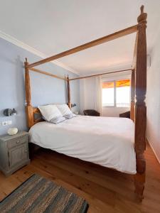 a bedroom with a large bed with a wooden canopy at Beach Apartment with Stunning View in Can Pastilla