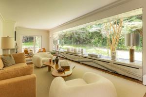 a living room with white furniture and a large window at Casa da Ribeira in Colares