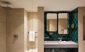 un baño con lavabo y espejo en Hotel Indigo Berlin - East Side Gallery, en Berlín 73 fotos más