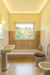 a bathroom with a sink and a toilet and a window at Casa da Ribeira in Colares