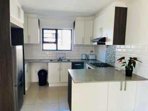 a kitchen with white cabinets and a counter top at Mount Pleasant Suites in Port Elizabeth