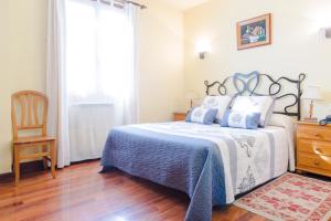 a bedroom with a bed and a chair and a window at Hotel Alameda in Zarautz
