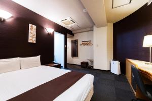 東京にあるUrvest Hotel Kamataのベッドと机があるホテルの部屋